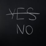 Handwritten chalk decision concept with 'yes' crossed out and 'no' emphasized.