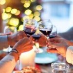 woman in white long sleeve shirt holding wine glass