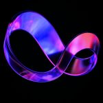 a close up of a purple ribbon on a black background