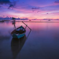 sunrise-phu-quoc-island-ocean-33582 A tranquil sunrise over a tropical ocean with a solitary boat reflecting peaceful hues.
